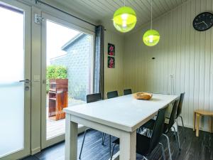 une salle à manger avec une table et des chaises blanches dans l'établissement Boutique Chalet in B llingen Near Lake, à Wirtzfeld
