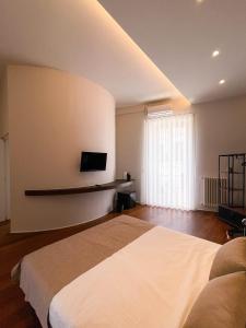 een slaapkamer met een bed en een tv aan de muur bij Terrazzini Cibele in Andria