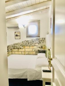 een witte kamer met een bed en een raam bij Borgo Camicia In in Barcellona-Pozzo di Gotto