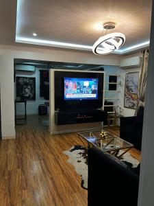 uma sala de estar com uma televisão de ecrã plano na parede em Charming one bedroom apartment 10 mins to the airport em Lagos