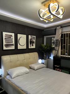 um quarto com uma grande cama branca e um lustre em Charming one bedroom apartment 10 mins to the airport em Lagos