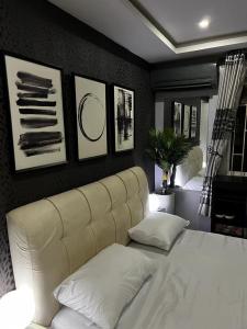 um quarto com uma cama branca e algumas fotografias na parede em Charming one bedroom apartment 10 mins to the airport em Lagos