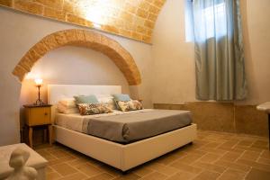 a bedroom with a bed in a room with an arch at LITHOS guest room in Barletta