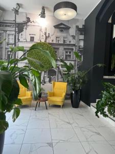 un soggiorno con due sedie gialle e piante di No1 Bed&Breakfast Restauracja ŚNIADANIE I PARKING W CENIE! a Leszno Altre 79 foto