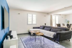 ein Wohnzimmer mit einem Sofa und einem Tisch in der Unterkunft Belle villa au calme avec piscine in Antibes