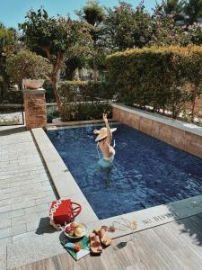 a woman in a swimming pool with a person in the water at JW Marriott Sanya Haitang Bay Resort & Spa in Sanya