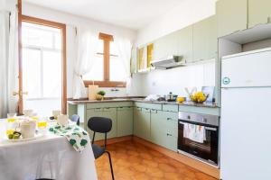 a kitchen with green cabinets and a table with a tablecloth at VibesCoruna - Outeiro 222 in A Coruña