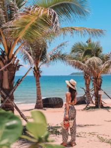 a woman standing on a beach with palm trees at JW Marriott Sanya Haitang Bay Resort & Spa in Sanya