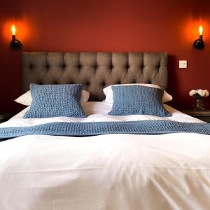 a bedroom with a large white bed with blue pillows at The Kings Head Inn, home of The Acle Steak in Acle