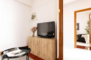 a living room with a television on a wooden cabinet at VibesCoruna - Outeiro 222 in A Coruña