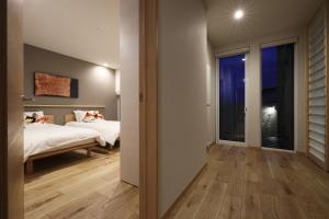 Una habitación de hotel con dos camas y una ventana. en AKATSUKI, en Furano