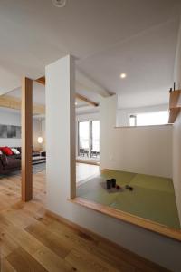 a living room with white walls and a green rug at AKATSUKI in Furano