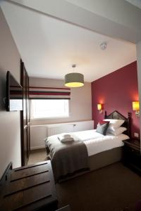 a hotel room with a bed and a nightstand at The Crown Inn in Stornoway