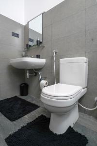 a bathroom with a white toilet and a sink at Regent Heights in Kandy