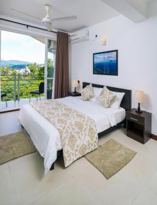 um quarto com uma cama e uma grande janela em Regent Heights em Kandy