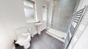 a bathroom with a shower and a toilet and a sink at Daventry House Stockton by Horizon Stays in Stockton-on-Tees +30 photos