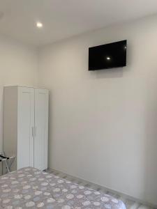 um quarto com uma cama e uma televisão na parede em La Bussola Airport Affitta Camere em San Giovanni Teatino