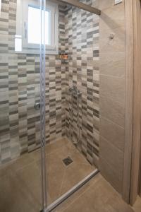 a shower with a glass door in a bathroom at Apanemo Kourouta Luxury Villas in Kourouta