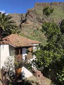 una casa blanca con una montaña en el fondo en Home2Book El Encanto De la Torre I, en Santa Cruz de Tenerife