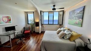 1 dormitorio con 1 cama, escritorio y 2 ventanas en Home2Book El Encanto De la Torre I, en Santa Cruz de Tenerife