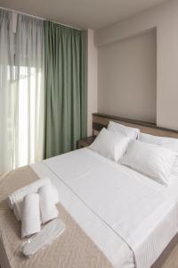 a bedroom with a large bed with white sheets and pillows at Apanemo Kourouta Luxury Villas in Kourouta