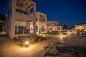a night view of a large white building with lights at Apanemo Kourouta Luxury Villas in Kourouta