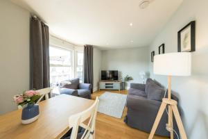 uma sala de estar com uma mesa e um sofá em North Street - 2 Bedroom Apartment - Hopewell em Bristol