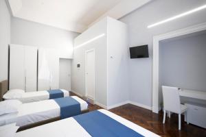 1 Schlafzimmer mit 2 Betten, einem Schreibtisch und einem TV in der Unterkunft La Chambre Duomo in Neapel