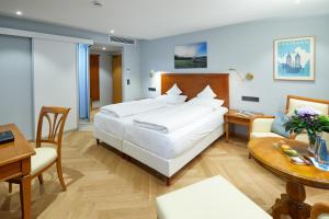 a hotel room with a large bed and a table at Erfurths Bergfried Ferien & Wellnesshotel in Hinterzarten