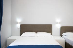 1 Schlafzimmer mit 2 Betten und 2 Leuchten an der Wand in der Unterkunft La Chambre Duomo in Neapel