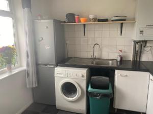 uma cozinha com uma máquina de lavar roupa e um lavatório em Charlie’s House Newmarket em Newmarket