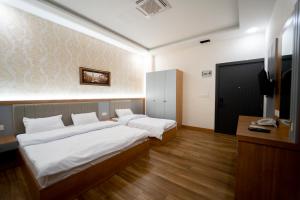 um quarto de hotel com duas camas e uma televisão em Havana Hotel em Dohuk