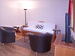 un soggiorno con divano, sedie e TV di Appartement Les Orres, 3 pièces, 8 personnes - FR-1-322-206 a Les Orres