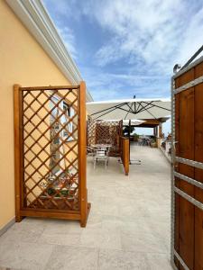 patio con rastrelliera per vini e ombrellone di Scapriccio Relax a Ischia