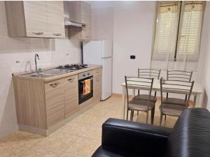 a kitchen with a sink and a table with chairs at Enea residence in Pozzuoli