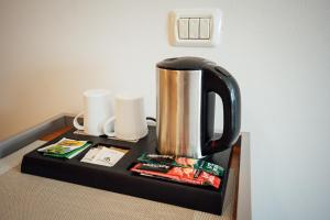 a coffee pot on a tray on a table at Sobe Rooms Nataly in Sežana