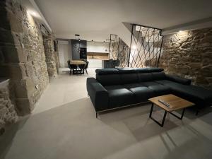 uma sala de estar com um sofá preto e uma mesa em Villa Copun with heated pool em Rab