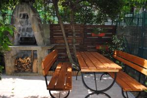 einem Picknicktisch und einer Bank neben einem Kamin in der Unterkunft Apartments Samec in Izola