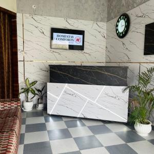 Homestay Comforts 500m from Amritsar Airport في أمريتسار: غرفة بها كونتر وساعة على الحائط