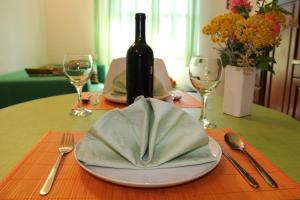 a table with a bottle of wine and a plate with a napkin at Apartments Stari Šibenik in Grebaštica
