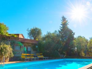a swimming pool with yellow chairs and the sun at Bright Farmhouse in Montecatini Terme with Swimming Pool in Pieve a Nievole