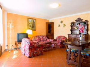 a living room with two chairs and a television at Bright Farmhouse in Montecatini Terme with Swimming Pool in Pieve a Nievole