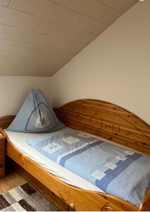 ein Holzbett mit einem Kopfteil aus Holz in einem Zimmer in der Unterkunft Ferienwohnung Kirchblick - a77305 in Liebenfels