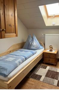 Schlafzimmer mit einem Bett mit blauer Bettwäsche und einem Dachfenster in der Unterkunft Ferienwohnung Kirchblick - a77305 in Liebenfels