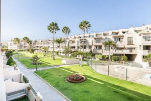 an apartment complex with palm trees and a lawn at Sunny Maria Apartment La Tejita Beach in Granadilla de Abona