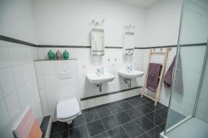 a bathroom with two sinks and a toilet and a shower at 150qm LOFT, Tischtennis, Dart, Tischkicker in Hamburg
