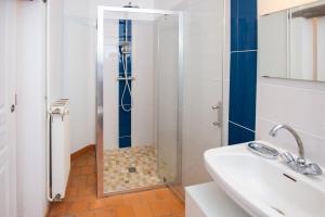 La salle de bains est pourvue d'une douche avec une porte en verre. dans l'établissement La croix des vignes, à Brossay