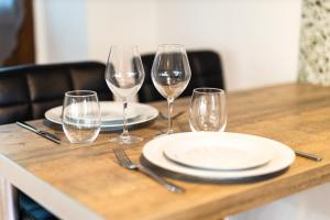 a table with four wine glasses and plates on it at La croix des vignes in Brossay +1 photo
