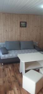 a room with a couch and a table in it at Pokoje&Domki Andrzej Kaczor in Pobierowo