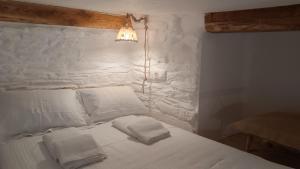 1 dormitorio con 1 cama blanca y 2 toallas en Est 1852 - Katoi Art, en Ándros